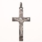 Pingente em prata representando cruz latina com Cristo crucificado em relevo aplicado e cartela com inscrição "INRI" na extremidade superior. Verso liso. Argola de suspensão integrada. Medidas: Alt.: 5 x Comp: 2,5 cm. Peso: 3.6 gramas.