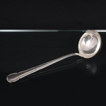 MERIDIONAL EPNS(100). Elegante concha para serviço confeccionada em metal espessurado à prata. Cabo de ponta arredondada, borda contornada com volutas relevadas, obtidas através da técnica do cinzelado. Marca da manufatura no verso do cabo. Medida: Comp.: 30 cm.