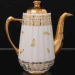 Bule para café em porcelana, corpo canelado de formato cônico, decoração aplicada em dourado e amarelo com motivos vegetalistas estilizados, bocal, tampa e alça integralmente dourados. Medidas: Alt.:18,5 x Comp.: 16,5 x Larg.: 9,5 cm.