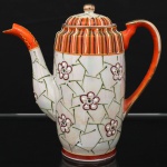 Bule para café em porcelana japonesa, corpo de perfil cilíndrico com leve afunilamento inferior, decoração policromada e em relevo composta por reservas florais estilizadas sobre fundo perolizado, faixa superior ornamentada por filetes verticais em laranja, azul, verde, branco e dourado.  Marca ao fundo JH acompanhada de caracteres japoneses. Medidas: Alt.: 17 x Comp.: 18 x Larg.: 8 cm.