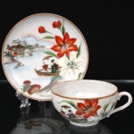 Xícara para chá em porcelana oriental, dita "casca de ovo", decorada em policromia sob esmalte com composição de paisagem lacustre, figura feminina em embarcação e flores de lírio em tons de vermelho e branco. Bojo hemisférico sobre pequeno pé anelar, com asa lateral em voluta e borda realçada por filete dourado. Marca em caracteres orientais ao fundo. Medidas: Xícara: Alt.: 4,8 x Diam.: 9,2 cm; Pires: Diam.: 13,5 cm.