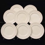 W.H. GRINDLEY, Staffordshire - Inglaterra(Fundada por William Harry Grindley em 1880). Conjunto de pratos rasos em faiança inglesa da década de 1940/50, padrão "Creampetal"; esmaltagem de tom marfim, decorado com frisos em douradura e tom coral, borda relevada com perolados e ondulações. Marca da manufatura no verso. Composto de oito(08) unidades. Medida: Diam.: 23 cm.