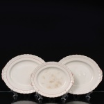 W.H. GRINDLEY, Staffordshire - Inglaterra(Fundada por William Harry Grindley em 1880). Três(03) travessa ovais em faiança inglesa da década de 1940/50, padrão "Creampetal"; esmaltagem de tom marfim, decorado com frisos em douradura e tom coral, borda relevada com perolados, ondulações e folhagens nos extremos laterais, Marca da manufatura no verso. Medidas: Comp.: 32 x Larg.: 26 cm. ; Comp.: 32 x Larg.: 26 cm. ;  Comp.: 26,5 x Larg.: 21,5 cm. . Apresentam marcas de uso e manchas do tempo.