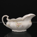 Johnson Bros, Hanley - Inglaterra(Fundada em 1883). Molheira navicular em faiança, corpo bojudo sobre base moldada, borda recortada com filetes dourados e decoração floral policromada em reservas. Alças e bocal modelados em linhas sinuosas. Marca da manufatura na base. Medidas: Alt.: 10 x Comp.: 20,5 x Larg.: 9 cm.