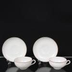 Xícara para chá em porcelana, dita "casca de ovo", esmaltação branca, bojo hemisférico sobre base circular, alça lateral em voluta, decoração em filetes dourados nas bordas. Marca da manufatura japonesa na face inferior, identificada por símbolo triangular com a inscrição Japan. Medidas: Alt.: 4,5 x Comp.: 10,5 x Larg.: 8,5 ; Pires: Diam.: 13 cm.