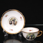 Porcelana Real, Mauá - SP(Fundada em 1943 por Fritz Erwin Schmidt). Xícaras para café em porcelana nacional, decoração policroma com reserva central representando busto feminino em traje de época, inspirada em retratos galantes do século XVIII, acompanhada por pequenas flores esmaltadas e filetes dourados. Bordas recortadas e alças douradas. Marcas da manufatura no verso. Medidas: Xícara: Alt.: 4 x Comp.: 8,5 x Larg.: 7 cm. ; Pires: Diam.: 10,5 cm.