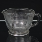 Copo medidor, em vidro prensado incolor, corpo com frisos verticais moldados, dotado de alça lateral e bico vertedor. Apresenta graduações em relevo para medidas de capacidade em cups e ounces (oz), com marcações até 2 cups / 16 oz. Medidas: Alt.: 9,5 x Comp.: 17 x Larg.: 13 cm.