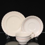 W.H. GRINDLEY, Staffordshire - Inglaterra(Fundada por William Harry Grindley em 1880). Trio para chá em faiança inglesa da década de 1940/50, padrão "Creampetal"; esmaltagem de tom marfim, decorado com frisos em douradura e tom coral, bojo hemisférico sobre base circular, asa lateral em voluta, bordas do pires e do prato relevadas com perolados e ondulações. Marca da manufatura no verso. Apresenta desgaste na douradura. Medidas: Xícara: Alt.: 5,5 x Comp. 12 x Larg.: 9,5 cm; Pires: Diam.: 14,5 cm; Prato: Diam.: 17,5 cm.