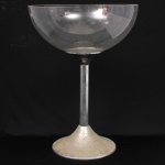 Champanheira em acrílico e metal, corpo de formato hemisférico apoiado sobre haste cilíndrica e base circular cônica. Utilizada para acondicionamento e serviço de garrafas de champanhe, espumante ou vinho em gelo. Design modernista. Medidas: Alt.: x cm. Diam.: x cm. Estado conforme fotografias, apresenta oxidação na base.(Este item não poderá ser enviado através dos correios).