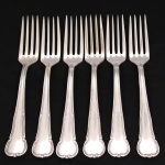 MERIDIONAL EPNS(100). Elegante conjunto de garfos grandes confeccionadas em metal espessurado à prata. Cabo de ponta arredondada, borda contornada com volutas relevadas, obtidas através da técnica do cinzelado. Marca da manufatura no verso do cabo. Composto de seis(06) unidades. Medida: Comp.: 20 cm.