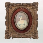 Quadro decorativo de parede contendo reprodução oval de retrato feminino identificado como Countess Grosvenor, após Sir Thomas Lawrence R.A. (17691830), moldura em resina de inspiração rococó executada com ornatos em relevo, volutas, flores estilizadas e acabamento dourado patinado. Cercadura interna revestida em tecido vermelho. Produção seriada decorativa, executada em linguagem revivalista inspirada no Rococó francês. Medidas: Alt.: 18,5 x Comp.: 17 cm.