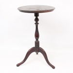 Mesa auxiliar circular, em madeira torneada. Tampo circular liso apoiado sobre coluna central torneada, assentada em base tripé de pernas arqueadas. No estado. Medidas: Alt.: 59 x Diam.: 34 cm.