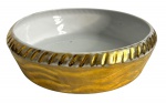 CERQUEIRA LEITE - Fruteira em porcelana esmaltada de branco no interior e vibrante ouro no externo. Desgaste do tempo. Possui registro CERQUEIRA LEITE. Borda canelada. Mede 28cm diâmetro.