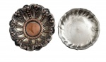 Par de porta-copos em metal, um com rica decoração em relevo de inspiração clássica, com elementos florais e centro em tom cobre, e outro de acabamento liso com borda recortada. Peças decorativas e funcionais, ideais para mesa posta ou coleção de metais. Mede 12 cm diâmetro.