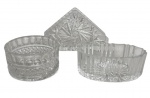 Conjunto em cristal translúcido composto por três peças: dois recipientes (um em formato redondo e outro oval) e um porta-guardanapos, com decoração em relevo geométrico e padrão estrela. Peças de uso e decoração, com leves sinais do tempo. Medida do maior 14cm.