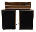 Sistema de som vintage, composto por toca-discos e rádio estéreo Grundig, modelo 505, em gabinete de madeira, com tampa acrílica basculante. Painel com equalização, sintonia AM/FM e selo Multi-Stereo. Acompanha par de caixas acústicas originais. Peça clássica do design alemão, ideal para coleção ou ambientação retrô. Funcionamento desconhecido. No estado.  Medida da vitrola 61 x 40. Medida da caixa 53 x 36 cm.