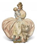 Escultura em porcelana esmaltada representando figura feminina em traje clássico segurando criança ao colo, acompanhada de cão aos pés, sobre base em forma de concha. Policromia suave em tons pastéis, rica em detalhes e expressão delicada. Peça de caráter decorativo. Possui discretos bicados. Contém assinatura não identificada no inferior. Mede 17x17cm.
