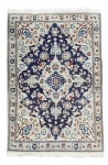 Tapete persa Nain decorado com medalhão central elaborado, rica decoração floral e paleta clássica em azul, marfim e toques de vermelho. Executado em lã de alta qualidade, com bordadura detalhada e excelente acabamento, peça elegante e de grande efeito decorativo. Mede 1,40 x 90 cm.