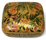 Caixa decorativa em madeira com acabamento em laca, ricamente policromada com fundo dourado e decoração floral e pássaros, de inspiração oriental. Interior em laca preta. Peça de caráter decorativo, com desgaste visível na tampa e sinais do tempo. Mede 11x9cm.