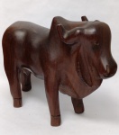 Escultura Boi Zebu Nelore em Madeira Maciça Nobre  Entalhe Manual Vintage Madeira maciça (aparenta ser jacarandá ou madeira de lei similar).Técnica: Entalhe manual com acabamento polido, destacando a anatomia do animal (cupim proeminente e barbela característica da raça).Estilo: Arte popular/regional brasileira, muito comum como peça de decoração de alto padrão em fazendas e escritórios de agronegócio no meados do século XX.