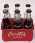 Raridade: Engradado de 6 Mini Garrafinhas Coca-Cola em VIDRO  Vintage Anos 50/60Vidro translúcido com o logotipo "Coca-Cola" e "Trade Mark Regd." em branco (decalque de época).Tampas: Metal (estilo coroa). Apresentam oxidação natural do tempo, o que atesta a antiguidade e originalidade da peça.Engradado: Plástico rígido vermelho com o logotipo clássico da época.