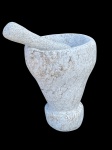 Escultura de pedra apicoada representando pilão , com mão, mede 35x26 cm diam.