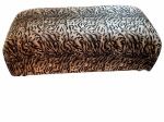 Grande puff estofado em tecido com estampa animal print (tigre). Medindo 125 cm x 70 cm x 43 cm alt. Possui rodinhas.