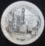 PRATO - PORCELANA - BRUGGE/BÉLGICA - DECORADO COM LUGAR TÍPICO DE BRUGGE - NAS CORES BRANCO E PRETO E  FILETADO À PRATA - 17 CM DIAM - CARIMBO NO VERSO