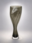 LINA BERGSTEN - Vaso artístico em cristal sueco Orrefors, assinado na base por Lina Bergsten. Datado de 1998. Elegante composição em vidro translúcido com aplicações orgânicas em branco leitoso fusionadas à massa, apresentando desenho escultórico de forte caráter contemporâneo. Destaca-se pela fluidez das formas, pureza do cristal e refinado domínio técnico característico da tradicional manufatura sueca Orrefors. Peça assinada Lina Bergsten e marcada Orrefors Sweden na base.