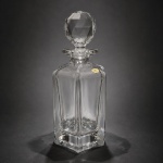 Garrafa para whisky em cristal Boêmia 24% PbOElegante garrafa para whisky em cristal Boêmia, confeccionada em cristal de alta qualidade com 24% PbO (óxido de chumbo), característica que confere excepcional transparência, brilho intenso e refinada sonoridade ao toque.A peça apresenta corpo de linhas geométricas sóbrias e elegantes, complementado por rolha lapidada facetada, destacando a tradição centro-europeia na manufatura de cristais finos. Seu desenho clássico e atemporal alia funcionalidade, requinte e forte apelo decorativo.