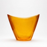 Vaso em acrílico  Cacá AlvarezElegante vaso escultórico em acrílico translúcido, de autoria de Cacá Alvarez, destacando desenho contemporâneo de forte apelo geométrico e refinada simplicidade formal. Executado em tonalidade âmbar, apresenta belíssimo efeito luminoso, transparência e profundidade visual, características que valorizam sua presença decorativa.