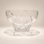 Centro de Mesa em Cristal  H. SternElegante centro de mesa em cristal da renomada H. Stern, destacando desenho sofisticado de linhas geométricas e lapidação precisa, características associadas ao refinamento estético da marca.Confeccionado em cristal transparente de elevada qualidade, apresenta marcante jogo de luz, brilho e transparência, evidenciando sua forma escultórica e forte presença decorativa. O desenho contemporâneo alia equilíbrio, requinte e apelo ornamental.