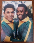 Página Vintage Rara: Pelé e Garrincha com o Agasalho da CBD (Anos 60)  Relíquia Histórica do Futebol BrasileiroRara e espetacular oportunidade para colecionadores de memorabília esportiva, historiadores do futebol e decoradores de ambientes temáticos! Lote composto por uma página/pôster original vintage trazendo a imagem da maior dupla da história do futebol mundial: Pelé (O Rei) e Mané Garrincha (A Alegria do Povo).