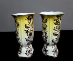 Par de floreiras, confeccionadas em porcelana, na cor branca e amarela, decorado flores em ouro velho.Obs: Um deles com bicado na borda. Med.: 18 x10 cm.