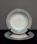 Conjunto de pratos de coleção, confeccionados em porcelana branca e azul claro, borda decorada com ramos de  flores, desenhos geomêtricos e friso dourado., sendo um prato raso e um prato fundo. Med.: 23 e 26 cm.