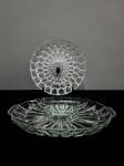 Lote com 2 peças, confeccionadas em vidro prensado, translúcido, sendo: Uma travessa redonda e uma petiqueira com 5 divisões. Med.: 5 x 18 e 4 x 35 x 22 cm.
