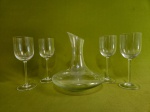 Lote com 5 peças em demi cristal translúcido, sendo um decanter e 4 taças de pé alto. Med: 23 x 21 e 21,5 x 8 cm
