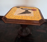Mesa lateral, confeccionada em madeira nobre, ricamente torneada, com tampo em mosaico, nas cores amarelo, branco e preto. Med.: 56 x 66 x 60 cm.  OBS: Retirada por conta do arrematante no Catumbi com agendamento prévio.