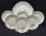 Rosenthal, selb Germany. Modelo Tirana. Conjunto para sobremesa em porcelana alemã, esmaltada, delicada decoração floral, filetes em ouro sobre fundo branco. Composto de prato para bolo e 6 pratos para sobremesa. Manufatura no verso. Medindo: 30 cm e 17 cm.
