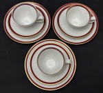 Renner. Três trios para chá em porcelana esmaltada, decorado com listra vinho e ouro, sob fundo branco. Manufatura no verso. Prato mede; 17,5 cm. Uma xícara com bicado. 