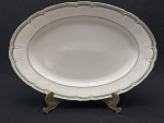 Vista Alegre, Portugal. Edição especial Confeitaria Colombo. Travessa oval em porcelana portuguesa esmaltada, decorada com listras verde e filetes em ouro sobre fundo branco. Borda ondulada. Manufatura no verso. Medindo; 46,5 x 32cm. Apresenta desgastes.