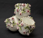 Vista Alegre. Portugal. Raro conjunto de porta-ovos de porcelana portuguesa da marca Vista Alegre, datado da década de 1950, com decoração floral em relevo de rosas, filetes em ouro e bordas rendilhada. Manufatura no verso. Medindo: 9,5 x 12 cm. Alguns discretos bicados nas folhas e rosas. 