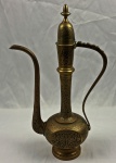 Antiga e elegante jarra oriental em bronze, de excepcional trabalho ornamental, apresentando corpo bojudo, longo gargalo e bico alongado em linhas sinuosas. A peça é ricamente gravada com delicados motivos florais e arabesco, Altura: 41 cm.