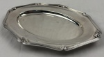 Fracalanza. Belíssima travessa oval em metal espessurado à prata, da afamada manufatura Fracalanza, modelo lacinho. Borda ricamente cinzelada. Medindo: 38 x 26,5 cm. Apresenta marcas de uso.