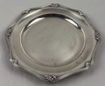 Fracalanza. Belíssima travessa redonda em metal espessurado à prata, da afamada manufatura Fracalanza, modelo lacinho. Borda ricamente cinzelada. Medindo: 33 cm. Apresenta marcas de uso. 