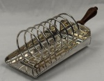 Elegante porta torradas em metal espessurado à prata, com pega em madeira. Medindo: 32 cm até a alça, 9 x 20 x 11 cm parte em metal.