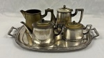 Fracalanza. Serviço para chá e café em metal espessurado à prata, bordas cinzelada, composto de bule de café, bule de chá, leiteira, açucareiro e bandeja. Medindo respectivamente; 16 x 21 x 7 cm, 13 x 22 x 9 cm, 12 x 18 x 7 cm, 11 x 29 x 9 cm e 48 x 31 cm.  Necessário banho de prata. 