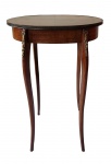 Mesa lateral estilo Luís XV, em madeira com tampo circular, cintura recortada e aplicações em bronze dourado. Apoiada sobre quatro pés cabriolés, com detalhes ornamentais em metal.. Medidas: 61 x 33 x 44 cm.