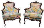 Par de poltronas estilo francês Luís XV, em madeira entalhada, com espaldar recortado, braços curvos e pés cabriolés terminando em delicados enrolamentos. Estofadas em tecido floral policromado, com acabamento em tachas decorativas. Medidas: 92 x 70 x 52 cm (Altura x Largura x Profundidade). Apresentam desgastes, manchas e sinais do tempo no estofamento.