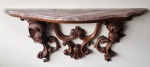Aparador / Console de parede em madeira ricamente entalhada, com tampo em mármore de formato recortado. Estrutura decorada com volutas, concheados e figuras de querubins alados, barroca/rococó de influência francesa. Medindo: 53 x 115 x 23 cm.
